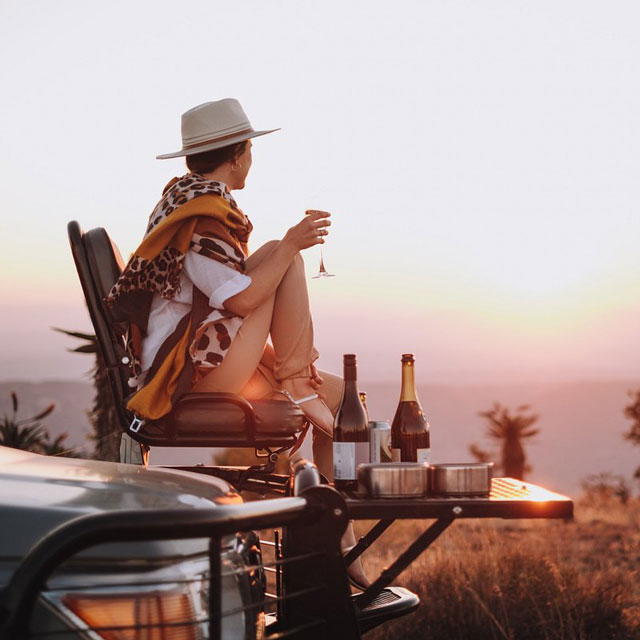 Woman enjoying the sunset on vehicle in Africa.