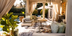 Elegant outdoor villa terrace with pool, draped curtains and African-inspired décor at Fairlawns Boutique Hotel and Spa, Johannesburg