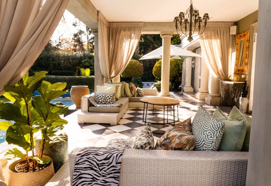 Elegant outdoor villa terrace with pool, draped curtains and African-inspired décor at Fairlawns Boutique Hotel and Spa, Johannesburg