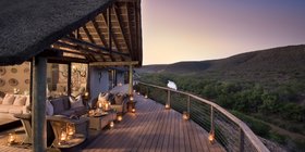Candlelit deck overlooking the Great Fish River valley at dusk at Kwandwe Great Fish River Lodge, Eastern Cape