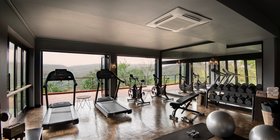 Well-equipped gym with floor-to-ceiling windows and panoramic bush views at andBeyond Phinda Mountain Lodge, KwaZulu-Natal