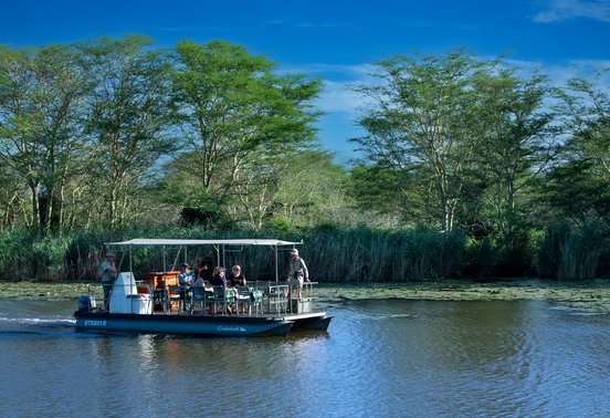 Guests on a guided boat safari through lily-covered wetlands in Phinda Private Game Reserve, KwaZulu-Natal, South Africa