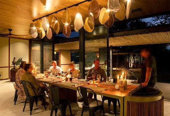 Guests dining by candlelight under sculptural pendant lights at Tanda Tula Safari Camp, Timbavati, South Africa