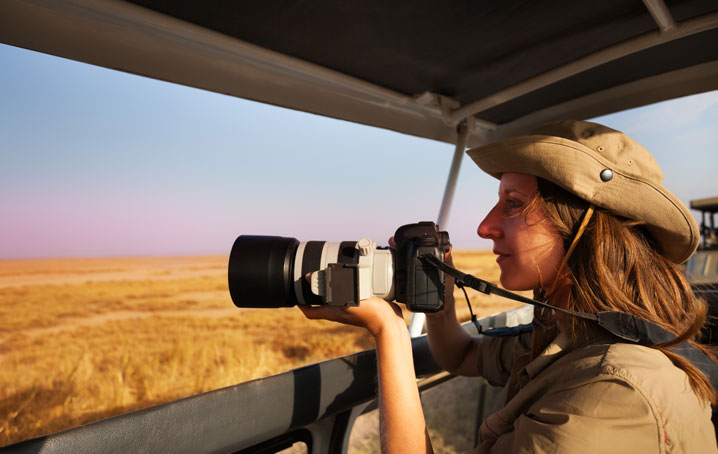 A woman on safari photographing animals.