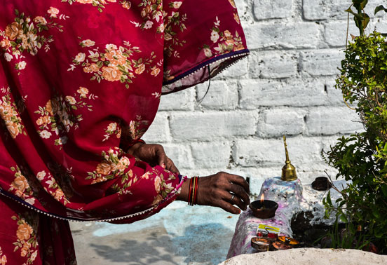 A woman lighting a candle in Khajuraho