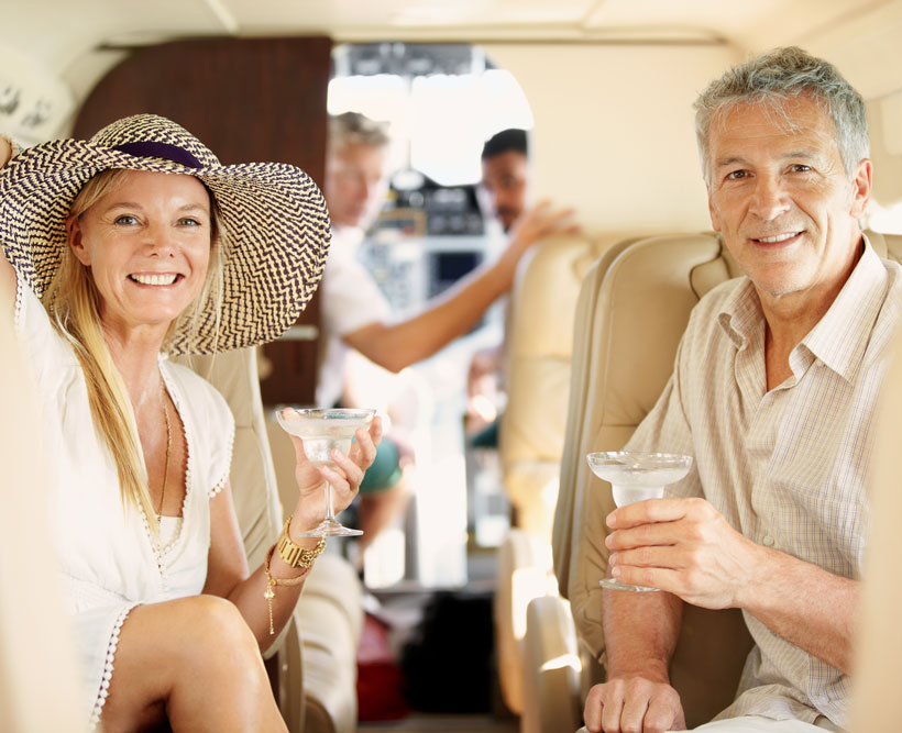 A couple enjoying drinks on a private jet