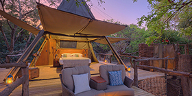 Tented suite exterior at dusk illuminated by lanterns at Shawa Luangwa Camp, South Luangwa National Park.