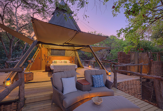 Tented suite exterior at dusk illuminated by lanterns at Shawa Luangwa Camp, South Luangwa National Park.