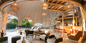 Open-air lounge of Ila Safari Lodge featuring modern eco-luxury design and natural textures overlooking the bush.