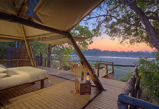 Open-fronted tented suite at Shawa Luangwa Camp overlooking the Luangwa River at sunrise, South Luangwa National Park.