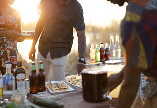 Guests enjoying sundowners and local bites during golden hour on the banks of the Zambezi River, arranged by Tongabezi Lodge.