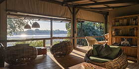 Riverside lounge at Shawa Luangwa Camp with woven chairs and panoramic views of the Luangwa River.