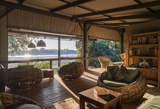 Riverside lounge at Shawa Luangwa Camp with woven chairs and panoramic views of the Luangwa River.