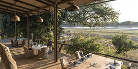 Open-air dining deck at Shawa Luangwa Camp set above the Luangwa River in South Luangwa National Park.