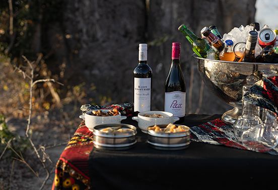 Bush bar setup with wine and cocktails at sundown, arranged by Ila Safari Lodge in Kafue National Park.