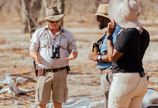 Safari guide briefing guests during a walking safari experience in Hwange, Zimbabwe