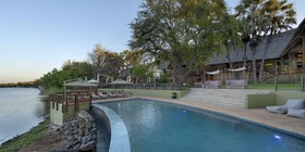 Swimming pool and sun deck overlooking the Zambezi River at dusk at David Livingstone Safari Lodge, Livingstone, Zambia