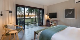 Modern king bedroom with floor-to-ceiling Zambezi river views and private balcony at David Livingstone Safari Lodge, Zambia