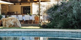 Insinka Lodge pool reflecting the open-air dining pavilion amid lush gardens, Victoria Falls, Zimbabwe