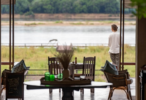 Guest gazing over the Zambezi River from Royal Zambezi Lodge's open-plan dining area, Lower Zambezi National Park, Zambia