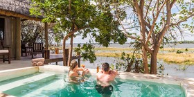 Couple relaxing in a private plunge pool overlooking the Zambezi River at Royal Zambezi Lodge, Lower Zambezi, Zambia