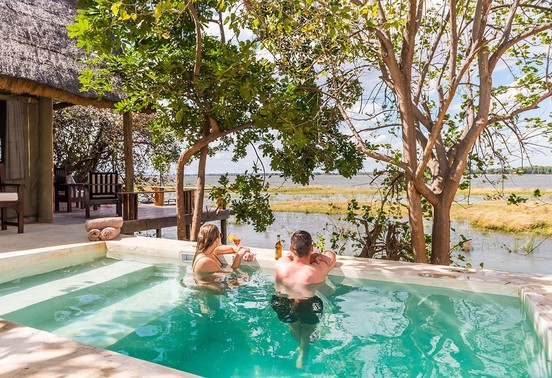 Couple relaxing in a private plunge pool overlooking the Zambezi River at Royal Zambezi Lodge, Lower Zambezi, Zambia